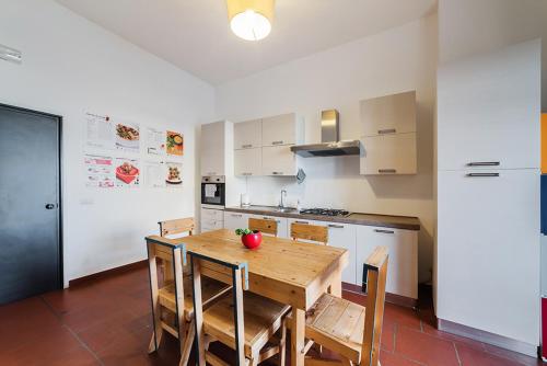 a kitchen with a wooden table with chairs and a refrigerator at Palazzo Verrone in Bari