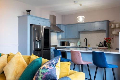 uma cozinha com um sofá amarelo e armários azuis em Stylish Beachfront Bolthole with Stunning Sea Views and Luxury Touches em Herne Bay