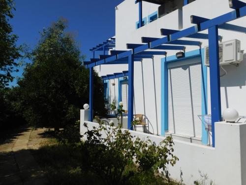 a white building with blue beams on it at Anna Ageliki in Damnoni