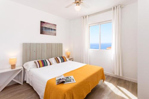 Habitación blanca con cama y ventana en Valhalla Rincón, en Rincón de la Victoria