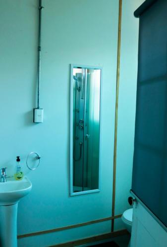 a bathroom with a sink and a shower with a mirror at Casa Bike in Punta Arenas