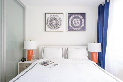 1 dormitorio con 1 cama blanca y 2 lámparas en 75-1C New 1BR prime UES W D the unit Best Value, en Nueva York