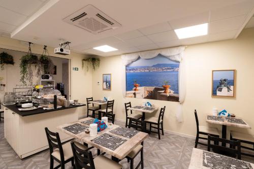 een restaurant met tafels en stoelen en uitzicht op de oceaan bij Rooms Boutique Carducci in Trieste