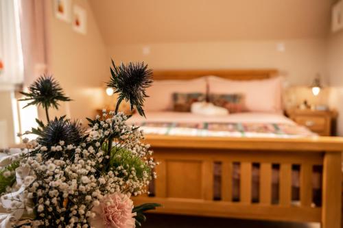 a bedroom with a bed with a bunch of flowers at Carters Rest Guesthouse in Milovaig