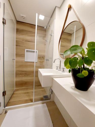 a bathroom with a shower and a sink and a mirror at Flores de Juquehy in Praia de Juquehy