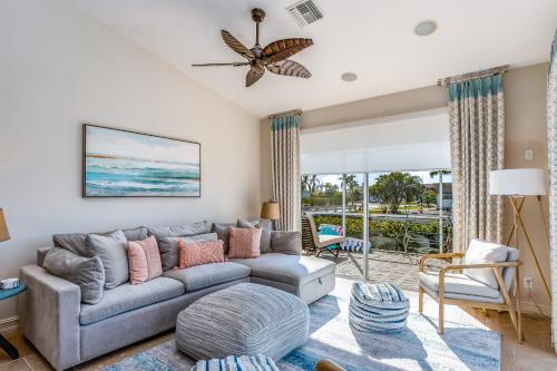a living room with a gray couch and a view of the ocean at Marco Paradise in Marco Island