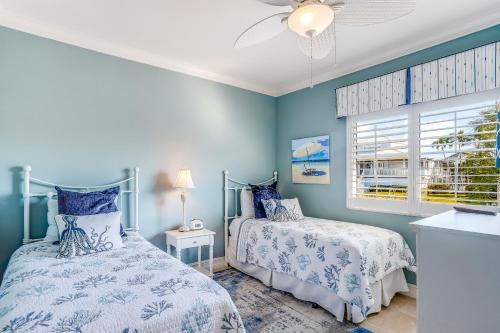 a blue bedroom with two beds and a window at Marco Paradise in Marco Island