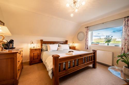 a bedroom with a bed and a window at Carters Rest Guesthouse in Milovaig