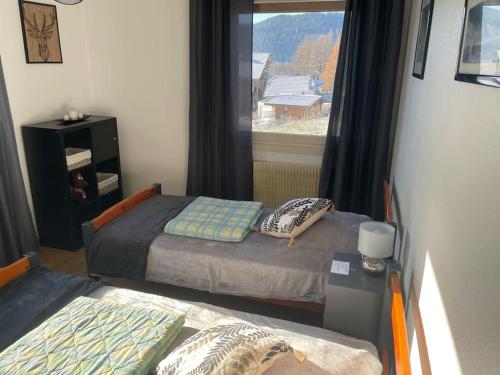 sypialnia z dwoma łóżkami i oknem w obiekcie Entre Lac et Montagne 4/6 personnes w mieście Gérardmer