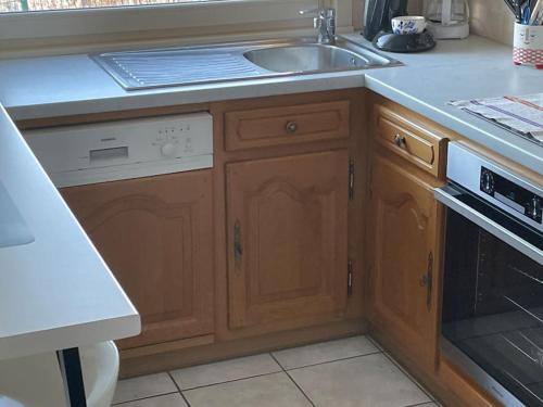 une cuisine avec un évier et une cuisinière dans l'établissement Entre Lac et Montagne 4/6 personnes, à Gérardmer