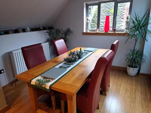 uma mesa de jantar com cadeiras vermelhas e uma mesa de madeira em Riverside 2 bed apartment Bewdley Worcestershire em Bewdley