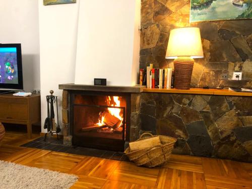 a living room with a stone fireplace with a lamp at Apartamento en Llívia ideal 8 personas con piscina in Llivia