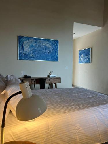 a bedroom with a bed with a table and a painting at CASA RIVERA DE MORAS in San Luis Soyatlán