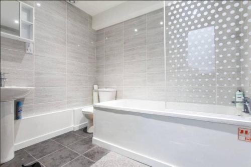 a bathroom with a tub and a toilet and a sink at Double room with shared facilities in London