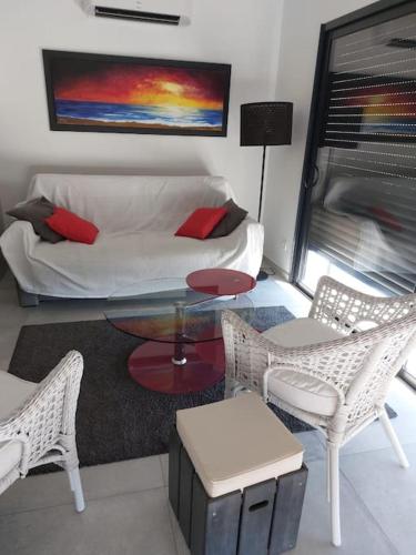 un salon avec un canapé, une table et des chaises dans l'établissement Cap Sud,apt 4p,vue mer,pr plage, au Lavandou