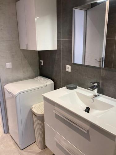 une salle de bain avec un lavabo, des toilettes et un miroir dans l'établissement Cap Sud,apt 4p,vue mer,pr plage, au Lavandou