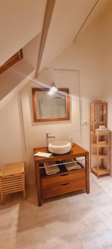 a bathroom with a sink on a wooden table at Un Parfum de Campagne in Méaulte