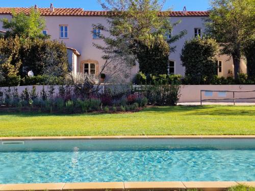 a house with a swimming pool in front of a yard at Tenuta Santa Caterina in Portoferraio