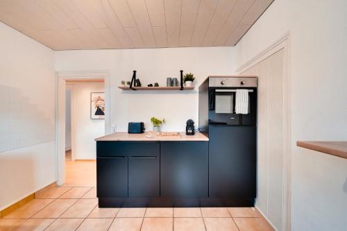 a kitchen with a black refrigerator and a counter at Stuttgart am Wasen Toplage 4Zi 80qm in Stuttgart