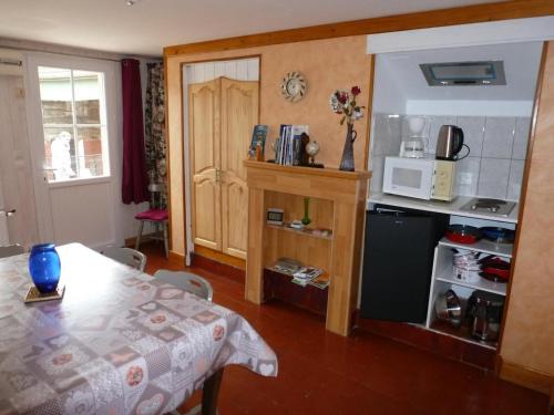 - une cuisine avec une table et un four micro-ondes dans l'établissement Gîte familial avec jardin, terrasse, vélos, Wifi, et animaux acceptés near Saint Pol sur Ternoise - FR-1-376-47, à Fiefs