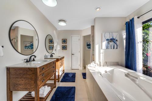 uma casa de banho com 2 lavatórios, uma banheira e um espelho grande em Outdoor Oasis by Beaches em Gulf Breeze