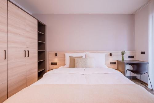 a bedroom with a large white bed and a desk at Schafalm Dahoam in Schladming