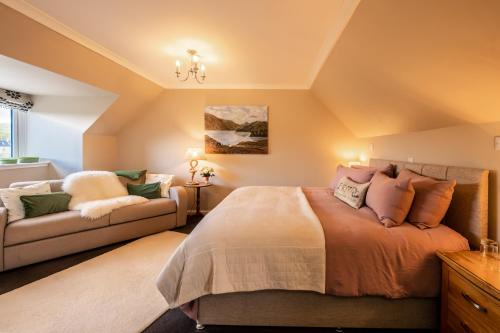 a bedroom with a bed and a couch at Carters Rest Guesthouse in Milovaig
