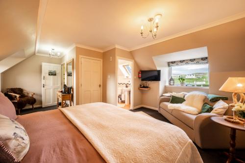 a large bedroom with a bed and a couch at Carters Rest Guesthouse in Milovaig