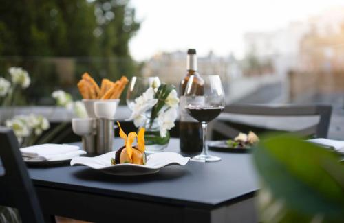a table with a glass of wine and a plate of food at COMO The Halkin in London