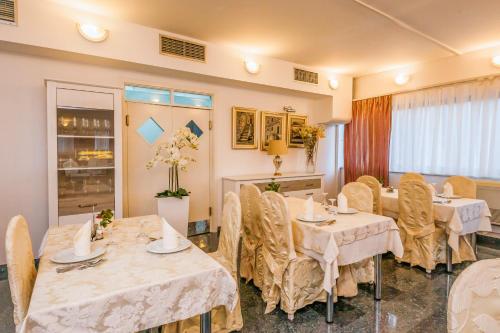 a restaurant with tables and chairs in a room at Hotel Bellevue Trogir in Trogir