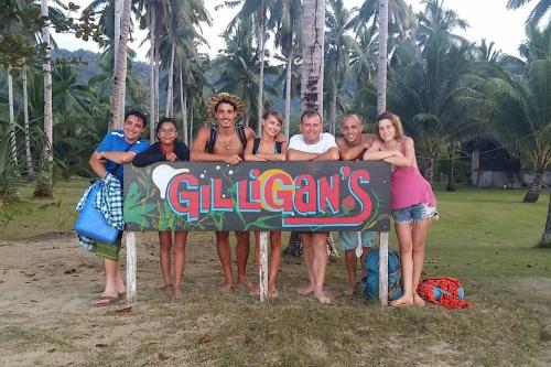 a group of people standing around a sign at Gilligans Port Barton Beach Resort in San Vicente