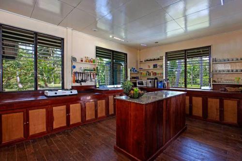 duża kuchnia z drewnianymi blatami i oknami w obiekcie Gilligans Port Barton Beach Resort w mieście San Vicente