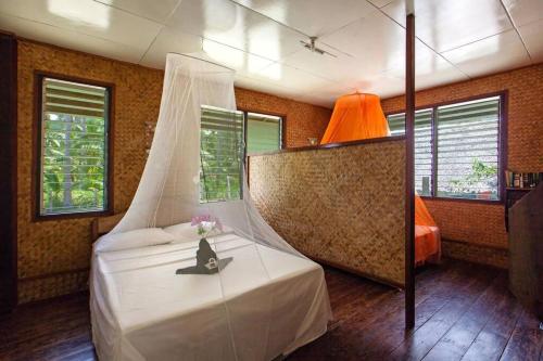 a bedroom with a bed with a white canopy at Gilligans Port Barton Beach Resort in San Vicente