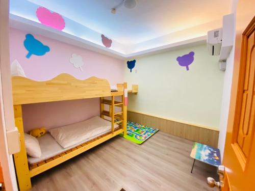 台東市的住宿－紅茶先生民宿 ，客房设有双层床,墙上挂有苹果壁画