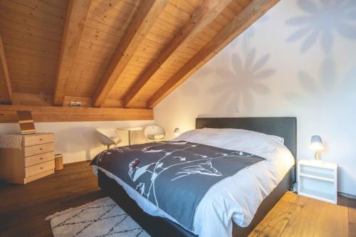 ein Schlafzimmer mit einem Bett und einer Holzdecke in der Unterkunft Chalet Talisman in Zermatt