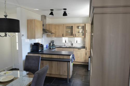 a kitchen with wooden cabinets and a black counter top at Woning zeldenrust 4 in Oostkapelle