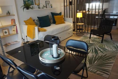 un salon avec un canapé, une table et des chaises dans l'établissement LE KENNEDY 1 - Studio proche hôpital, à Châteauroux