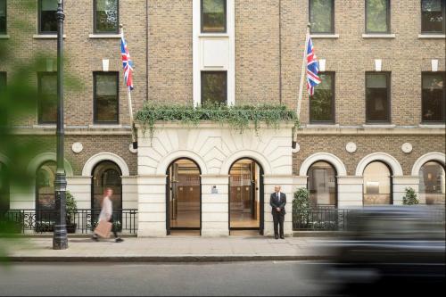 a man and woman standing in front of a building at COMO The Halkin in London