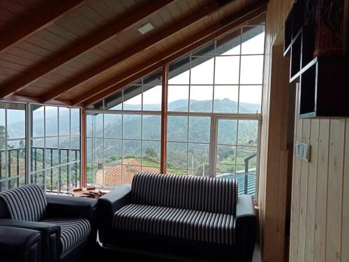 ein Wohnzimmer mit zwei Sofas und einem großen Fenster in der Unterkunft Villa sierra sky in Ambawela