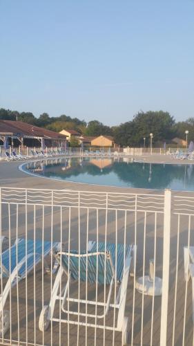 - une vue sur la piscine derrière une clôture dans l'établissement CARPE DIEM - La Villa des Vacances, à Soustons