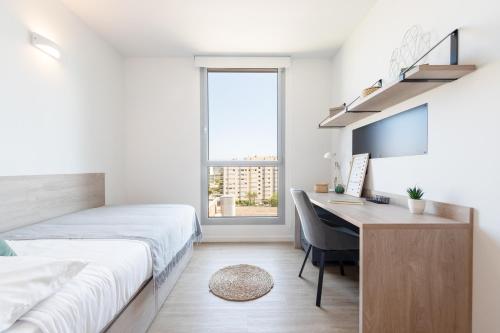 1 dormitorio con 1 cama y escritorio con ordenador en Micampus Barcelona, en Barcelona
