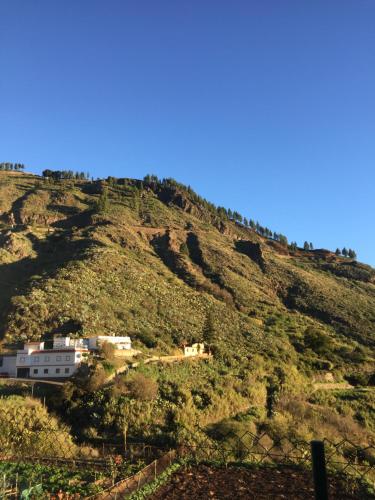 a hill with a house on top of it at Casa Azul Mountain Retreat in Vega de San Mateo