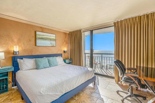 a bedroom with a bed and a desk and a window at Gulf Overlook San Luis Resort 1035 in Galveston