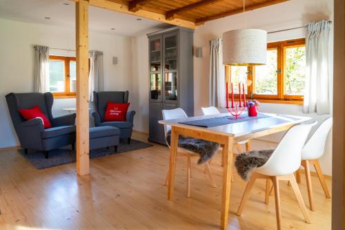 - une salle à manger et un salon avec une table et des chaises dans l'établissement Alpenchalet Sachrang, à Sachrang