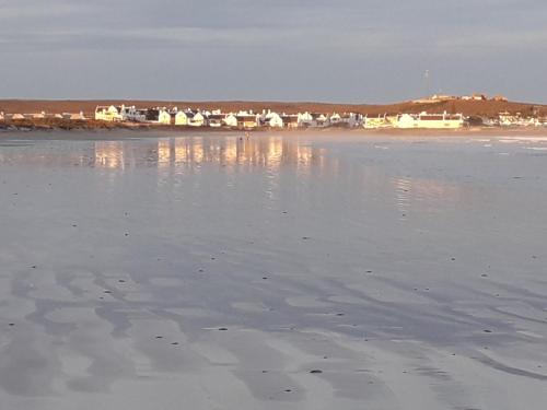 a view of the beach with houses in the background at Spacious loft in Paternoster