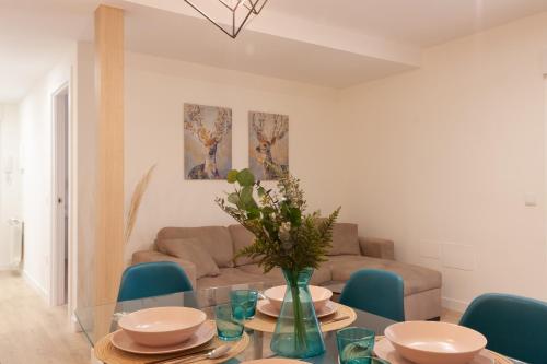 a living room with a glass table and blue chairs at Apartamento Premium PLAZA MAYOR con PARKING in Avila