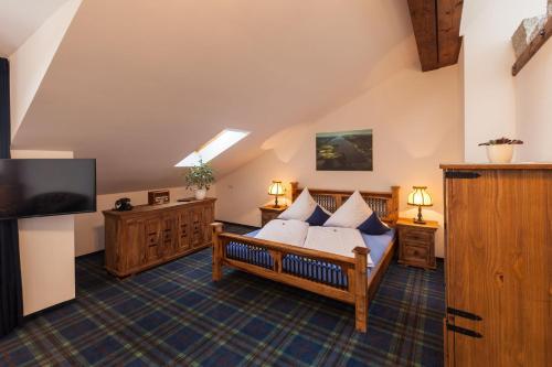 a bedroom with a bed and a flat screen tv at Vitusfort Doppelzimmer Loch Ness in Füssen