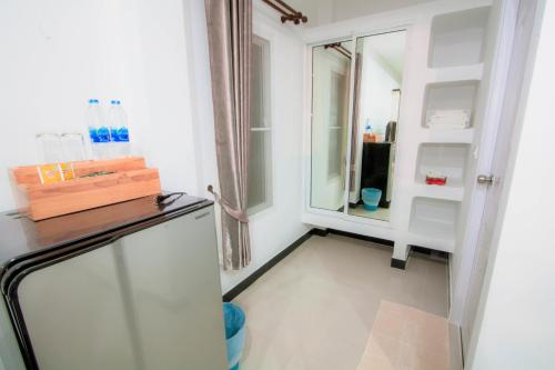 a small kitchen with a refrigerator and a mirror at Baan Opun Garden Resort in Hua Hin
