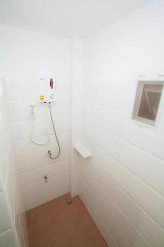 a white bathroom with a shower with a window at Baan Opun Garden Resort in Hua Hin