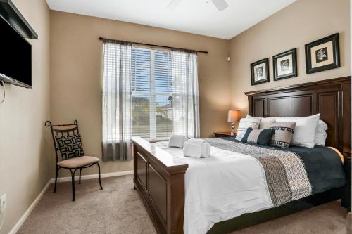 a bedroom with a bed and a chair and a window at Castle Street Memories in Kissimmee